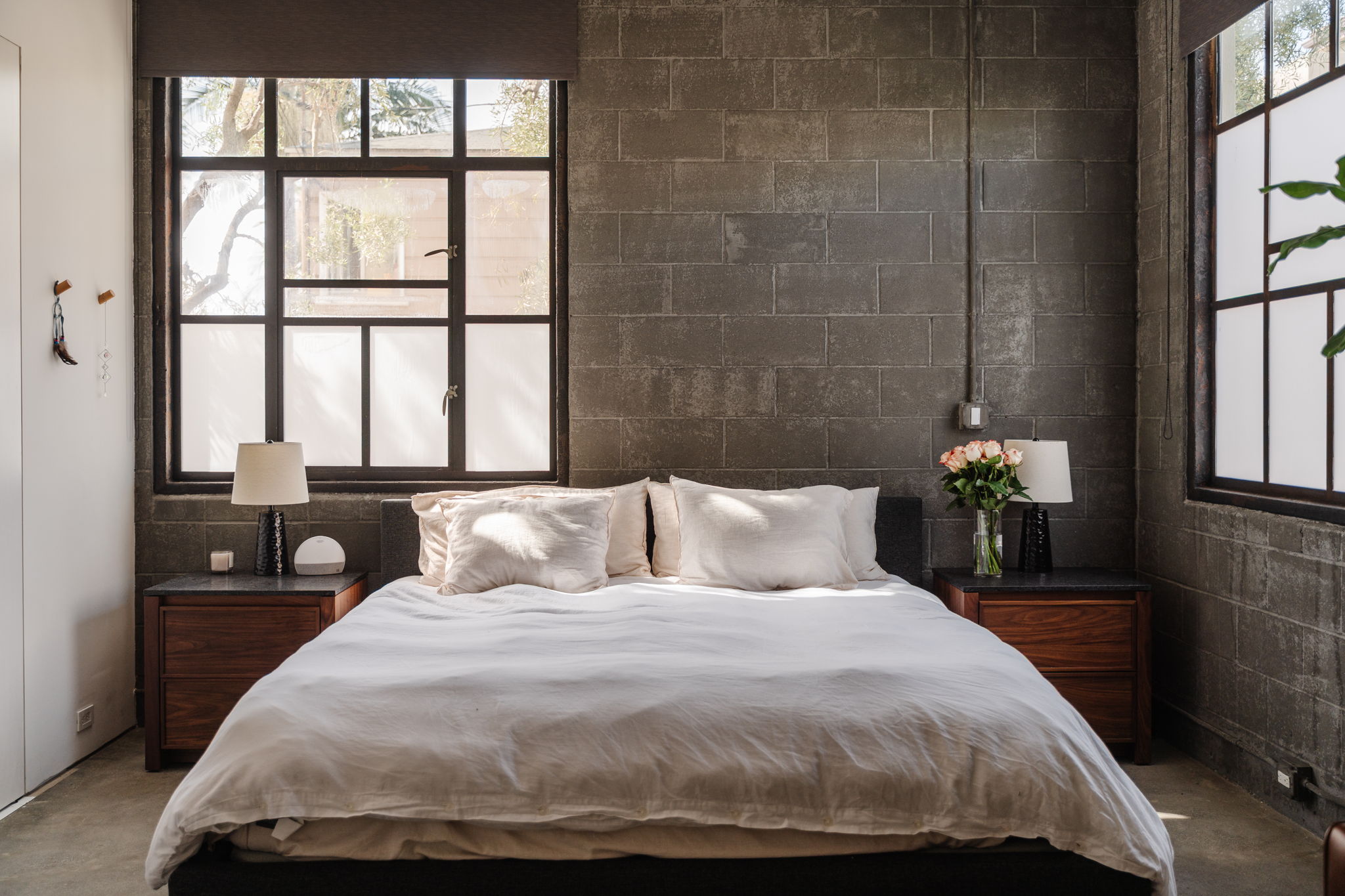 Bedroom with tall windows and textured concrete block wall