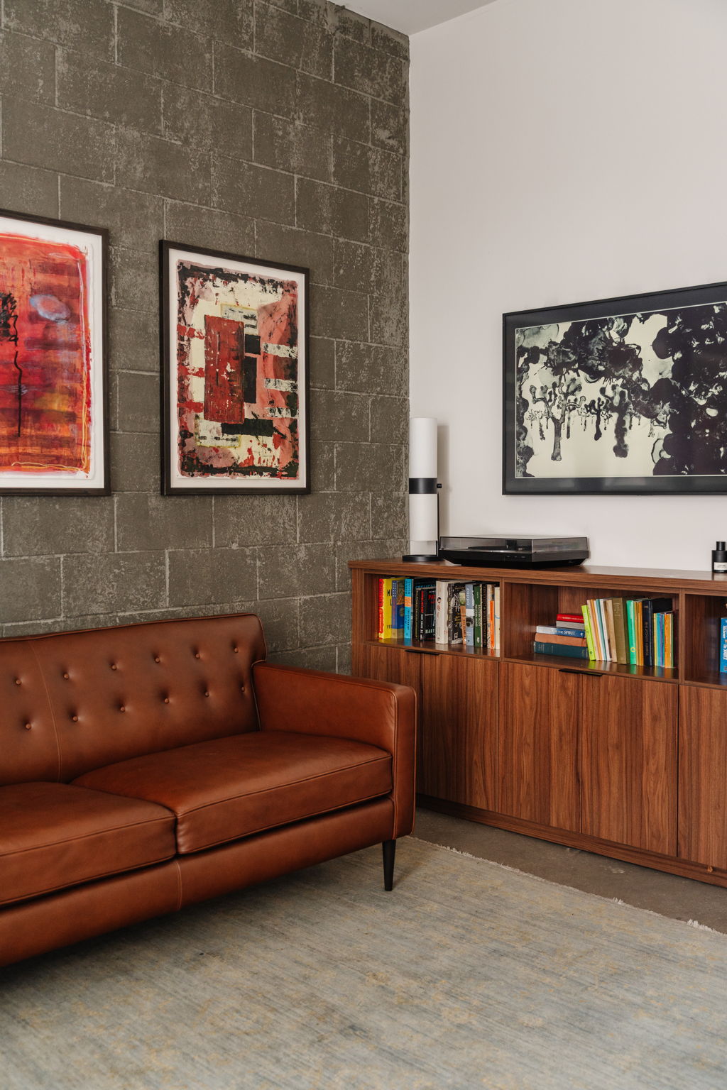 Close view of an untitled 2004 black and white drawing by Anna Rac beside red abstract artworks