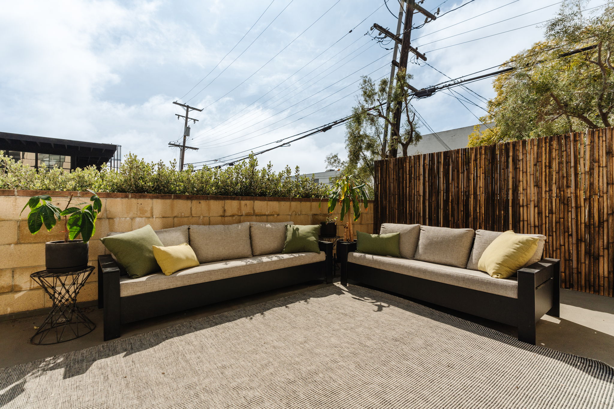 Sunny Santa Monica patio with outdoor sofas and bamboo privacy screen